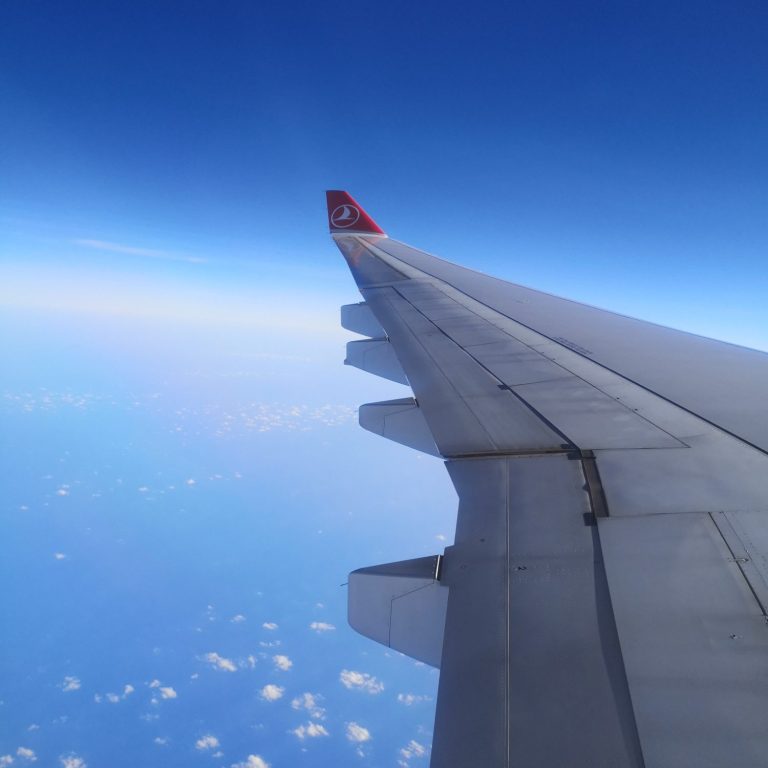 Tragfläche eines Flugzeugs Flügel eines Flugzeugs über wolkenlosem Himmel und blauer See.