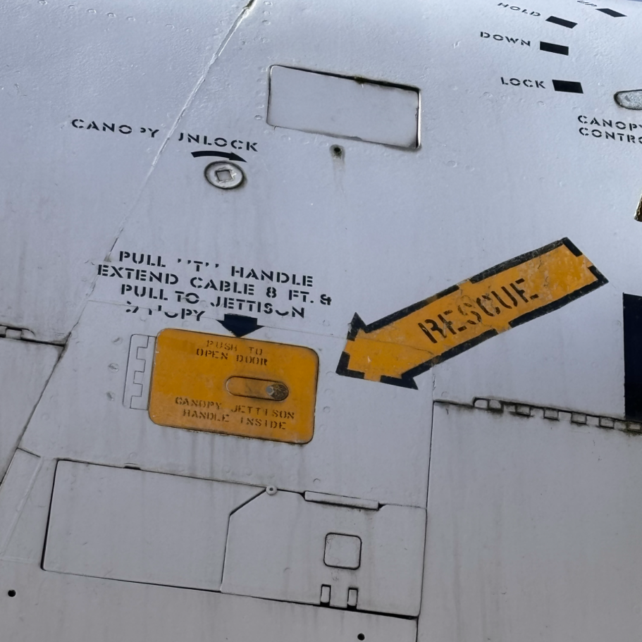 Nahaufnahme eines bemalten Panels mit einem Rettungshinweis und Warnaufkleber.