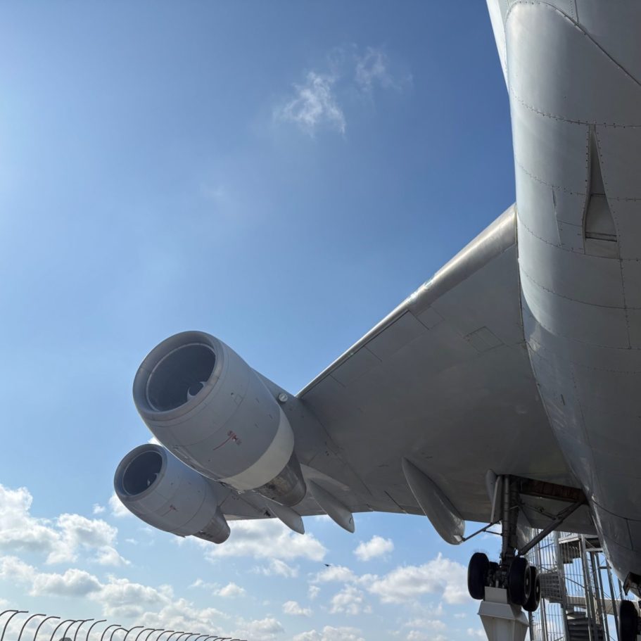 Detailaufnahme eines Flugzeugtriebwerks unter einem großen Tragflächenabschnitt.